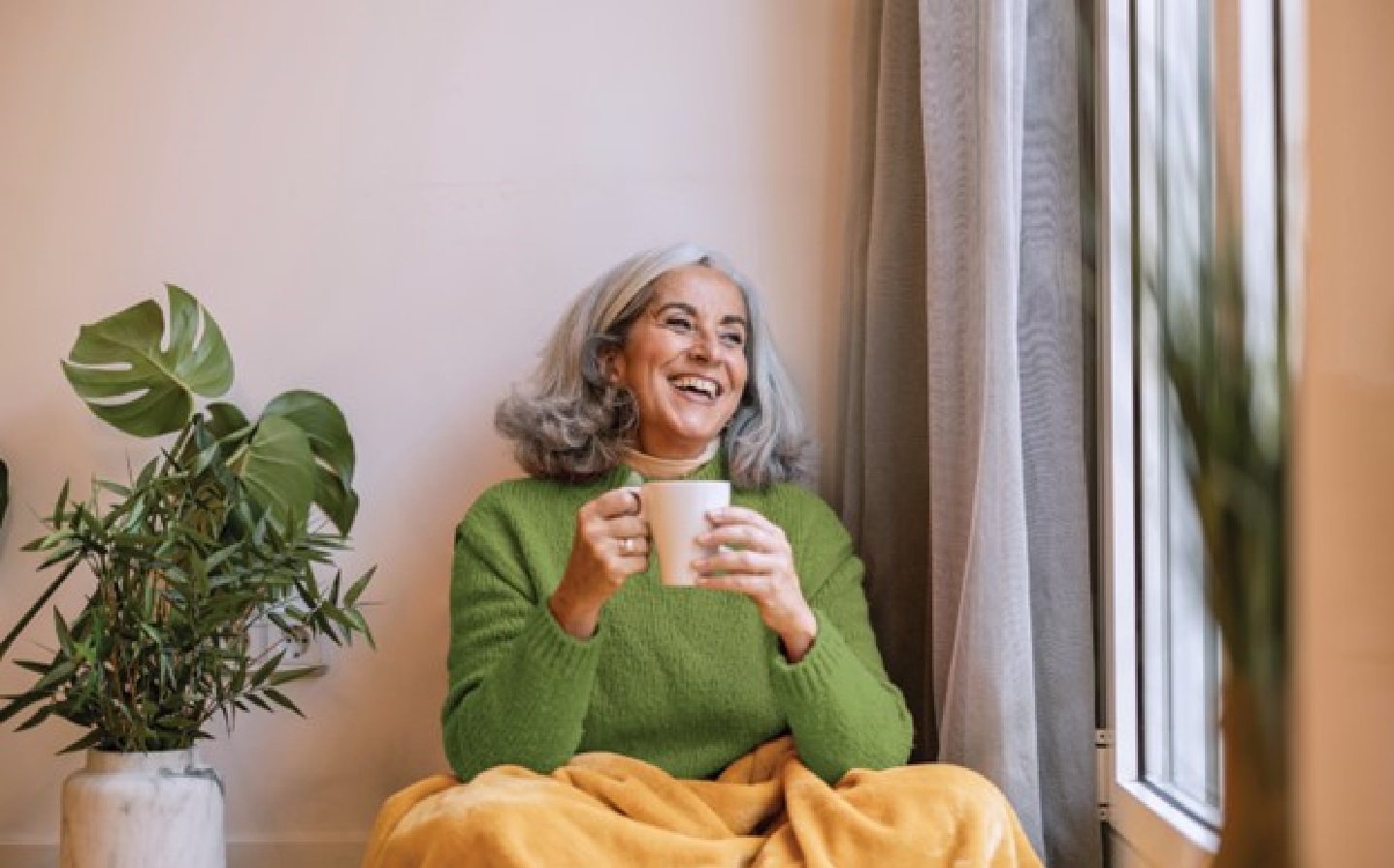 Older woman sitting drinking coffee