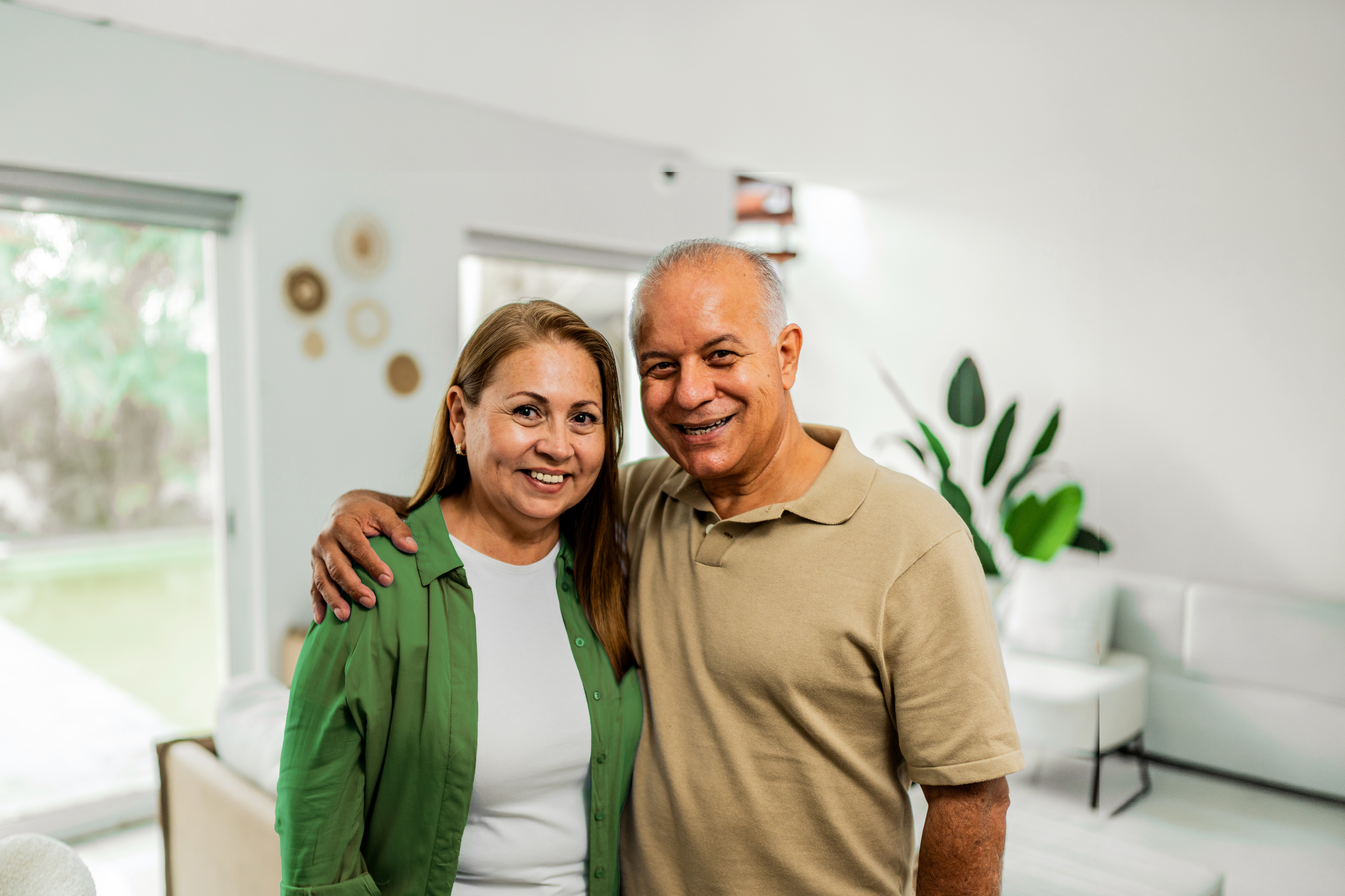 Smiling couple walking outdoors with trees in the background.